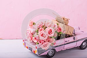 Retro car toy with pink roses and wrapped boxes with presents f