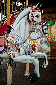 Retro carousel white, black horse. Old wooden horse carousel.