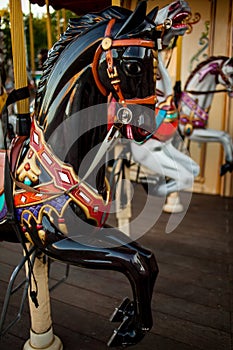 Retro carousel white, black horse. Old wooden horse carousel.