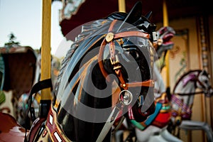 Retro carousel white, black horse. Old wooden horse carousel.