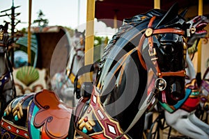 Retro carousel white, black horse. Old wooden horse carousel.