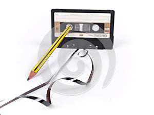 Retro cassette with loose tape and a pencil