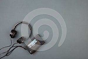 Retro cassette player with headphones on grey background