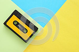 Retro cassette tape over yellow and blue double colorful background. top view. copy space.