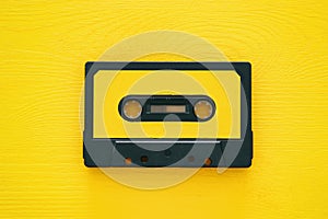 Retro cassette tape over yellow wooden table. top view.