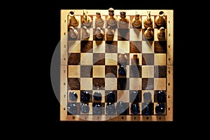 Retro chess board with figures from USSR on a black background. Chess opening Queen Gambit, top view