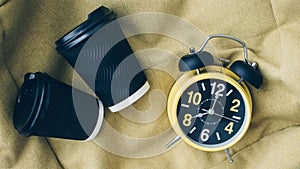 Retro clock with alarm clock and cappuccino,black coffee americano, drink concept,aromatic coffee,top view.Plastic cup for coffee. photo