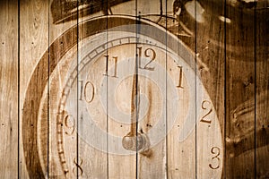 Retro clock on wood background selective focus at number 12 o`clock