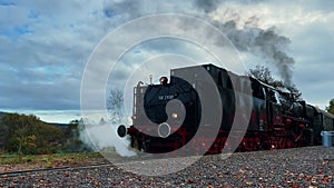Retro coal steam locomotive with smoke.Historic German train on railroad station