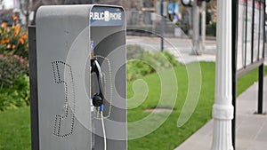Retro coin-operated payphone station for emergency call on street, California USA. Public analog pay phone booth