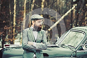 Retro collection car and auto repair by mechanic driver. Travel and business trip or hitch hiking. Bearded man in car