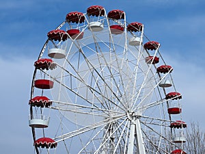 Retro colorful ferris wheel of the amusement park in the blue sky background.