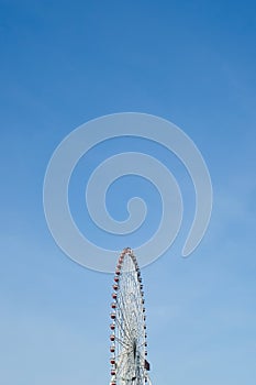 Retro colorful ferris wheel over the blue sky background.