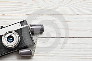 Retro compact photo camera and film on white
