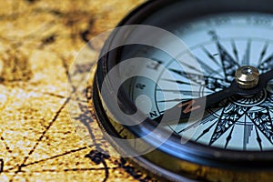 Retro compass on antique world map