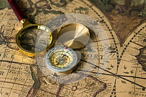 Retro compass with old map and magnifier