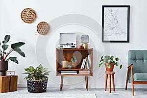 Retro composition of living room interior with mock up poster map, wooden shelf, book, armchair, plant, cacti, vinyl recorder.