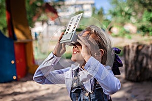 Retro device, soviet stereoscope. Cute girl watching 3D pictures with vintage slide viewer