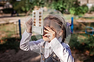 Retro device, soviet stereoscope. Cute girl watching 3D pictures with vintage slide viewer