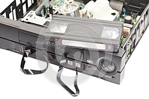 Retro disassembled video cassette recorders with broken VHS cassette with unwound tape isolated on white background