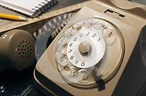 Retro disk telephone on a table with a pencil and a phonebook