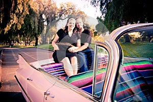 Retro dressed couple in pink Cadillac