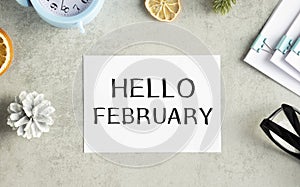 toned image of a woman hand writing a note with a fountain pen on a notebook. Handwritten text HELLO FEBRUARY,