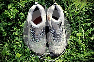 Retro Faded Photo Of Dirty Walking Boots In Green Grass