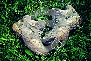 Retro Faded Photo Of Dirty Walking Boots In Green Grass