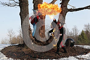 Retro fire-eater showing fire-show on forest