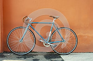 Retro fixed gear bicycle on brown concrete wall background