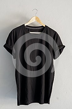 Retro fold Black cotton T-Shirt clothes mock up template on gray cement background concept for retail dress shop backdrop, Blank