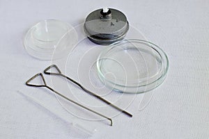 Retro. Glass Petri dishes, metal spirit lamp, metal loops and plastic pipette for the collection of biological fluids for bacterio