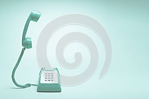 Retro green telephone on teal green background