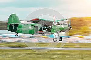 Retro green turbo propeller vintage aircraft flying over the car in the airport