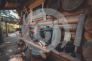 Retro houseware on a wooden bench near wooden wall. Antique household items