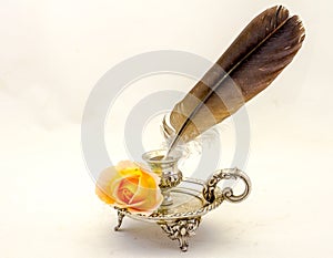 Retro inkwell feather writing pen and an orange rose