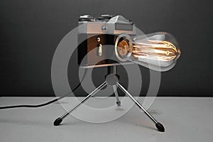 Retro lamp from an old camera with an Edison lamp on a gray background. Concept is a good idea