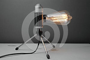 Retro lamp from an old camera with an Edison lamp on a gray background. Concept is a good idea