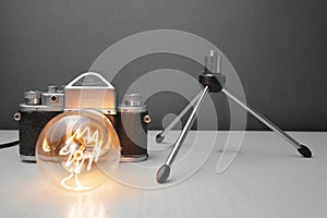 Retro lamp from an old camera with an Edison lamp on a gray background. Concept is a good idea