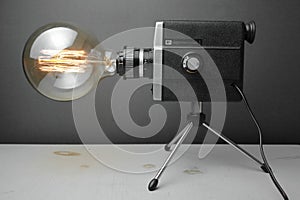 Retro lamp from an old camera with an Edison lamp on a gray background. Concept is a good idea