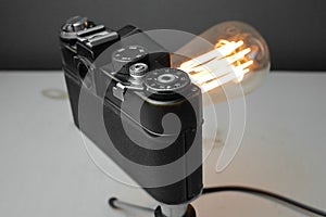 Retro lamp from an old camera with an Edison lamp on a gray background. Concept is a good idea