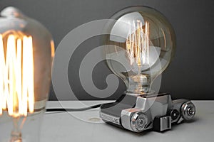 Retro lamp from an old camera with an Edison lamp on a gray background. Concept is a good idea