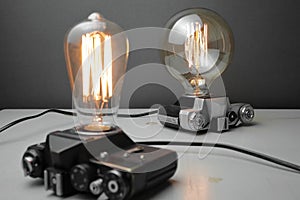 Retro lamp from an old camera with an Edison lamp on a gray background. Concept is a good idea