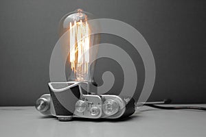 Retro lamp from an old camera with an Edison lamp on a gray background. Concept is a good idea