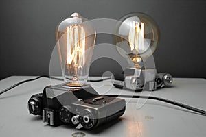 Retro lamp from an old camera with an Edison lamp on a gray background. Concept is a good idea