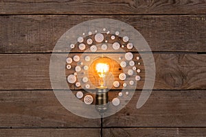 Retro light bulb and group of gears on wooden background - idea, innovation, teamwork and leadership concept. Space for text