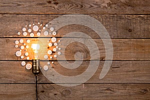 Retro light bulb and group of gears on wooden background - idea, innovation, teamwork and leadership concept. Space for text