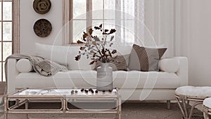 Retro living room in white and bleached wood tones closeup. Sofa, rattan table with autumn decors. Boho chic design, fall interior