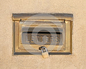 Retro mailbox wall mounted on yellow plaster wall background.